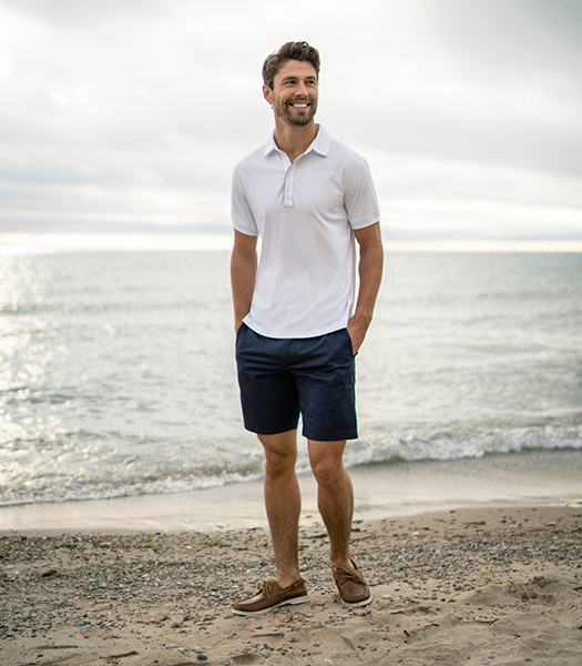 The featured image is a man standing in a living room wearing the Atlantic Moc Toe Venetian Slip On in Cognac.